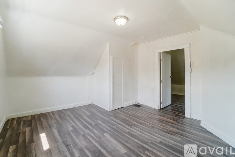 A room with wooden flooring and white walls.
