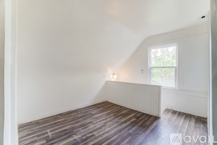 A room with wooden flooring and a window.
