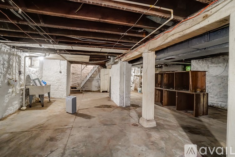 A large, empty basement with a concrete floor and exposed pipes on the ceiling.