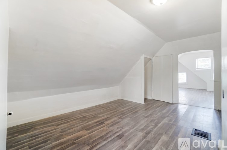 A room with wooden flooring and white walls.