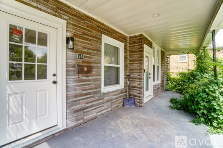 A wooden house with a white door and windows.