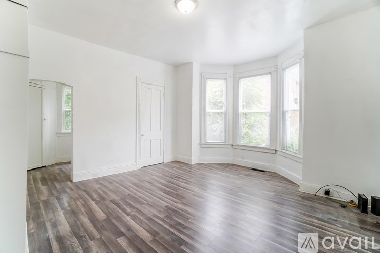 A room with wooden flooring and white walls.
