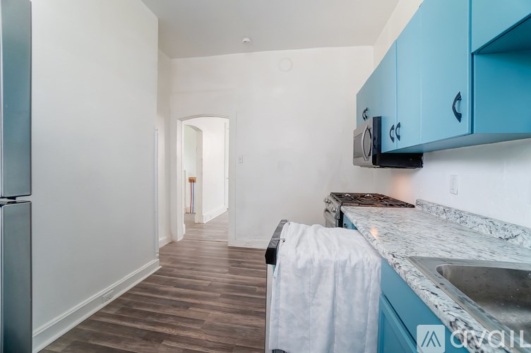 A kitchen with blue cabinets and a marble countertop.