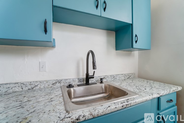 A kitchen sink with a faucet and blue cabinets.