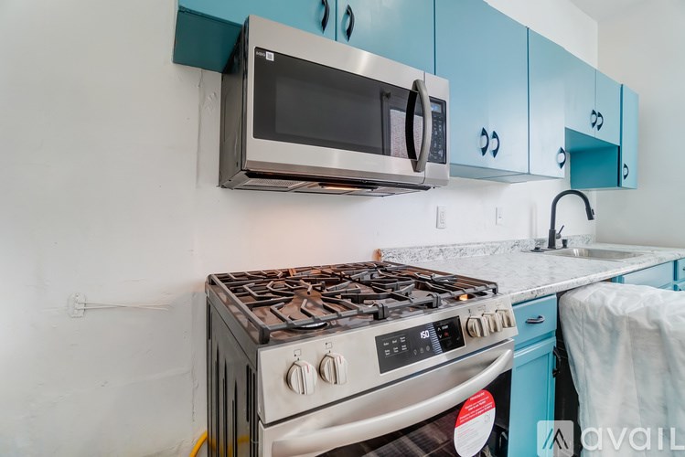 A kitchen with a stove, microwave, and cabinets.