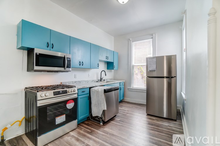 A kitchen with blue cabinets and a stainless steel refrigerator.
