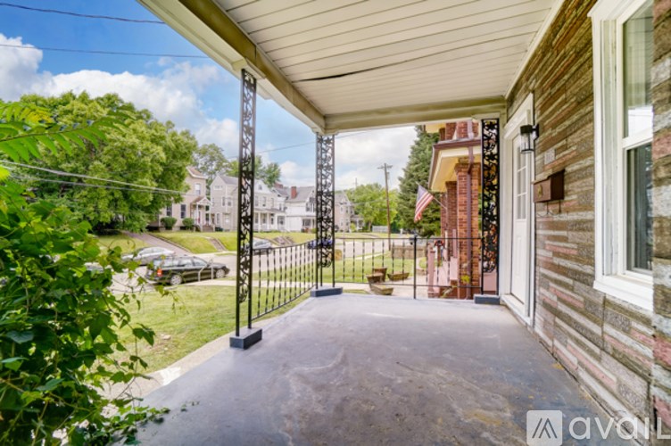 A porch with a black gate and a brick wall.