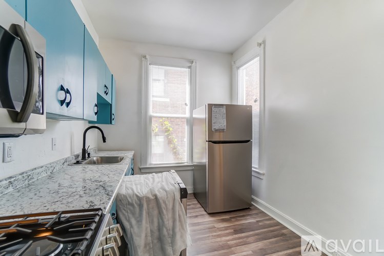 A kitchen with a marble countertop and blue cabinets.