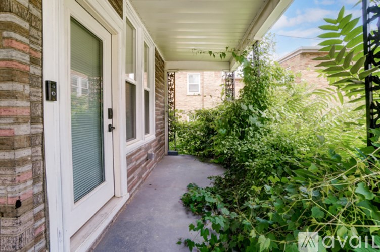 A house entrance with a glass door and a small garden.