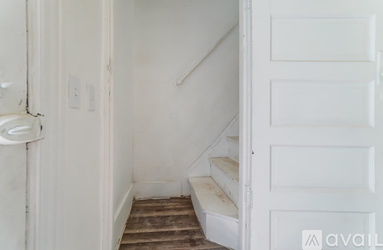 A white door is open to a stairway.