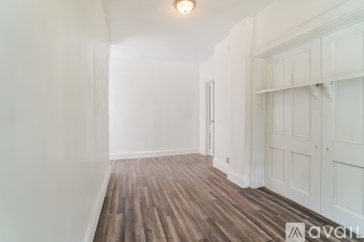 A room with wooden flooring and white walls.