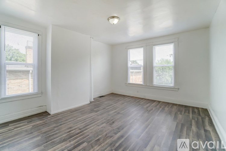 A room with wooden flooring and white walls.