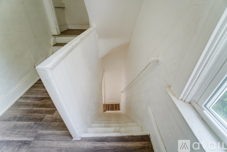 A staircase with wooden steps and a white railing.