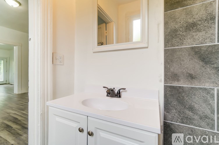 A bathroom with a white sink and a mirror above it.