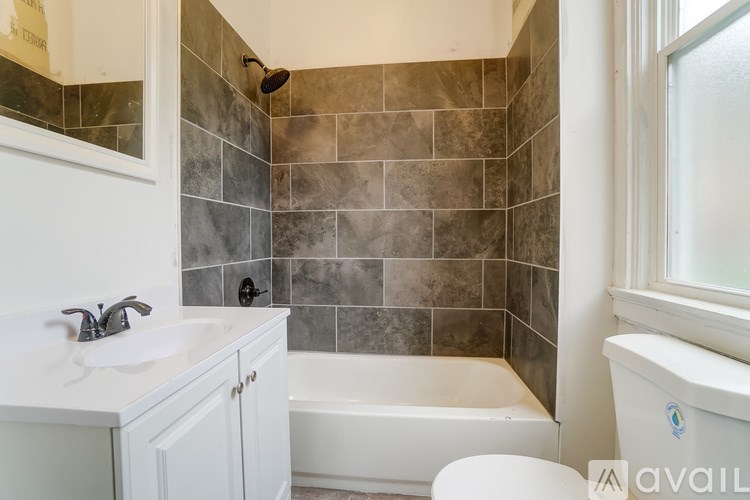 A bathroom with a white tub and sink.