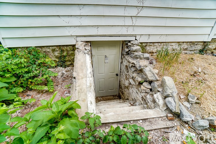 A white door is set into a stone wall.