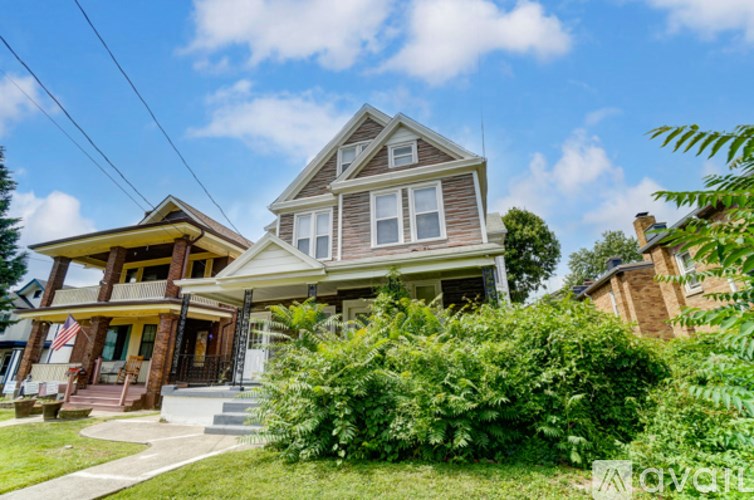 A large house with a porch and a flag on it.