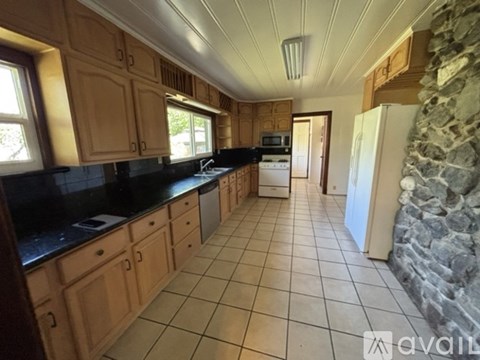 A kitchen with wooden cabinets and black countertops.