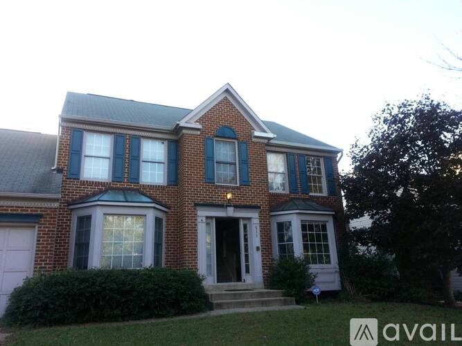 A brick house with a white door and windows.