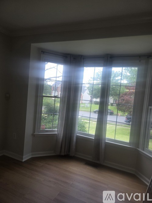 A room with a large window and wooden floors.