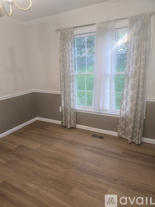 A room with a window and curtains.