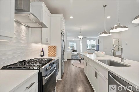 A modern kitchen with white cabinets and a black stove top oven.