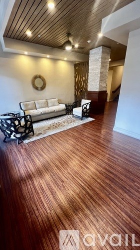 A living room with a white couch and a wooden floor.