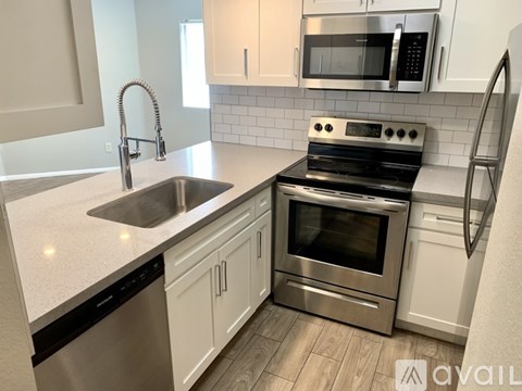 A modern kitchen with a stainless steel oven and white cabinets.