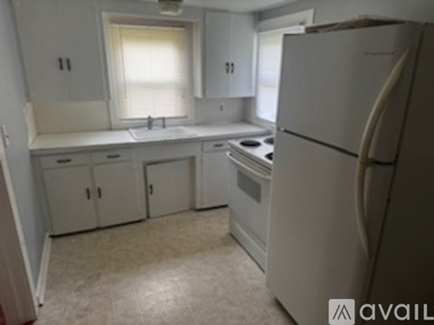 A kitchen with white appliances and cabinets.