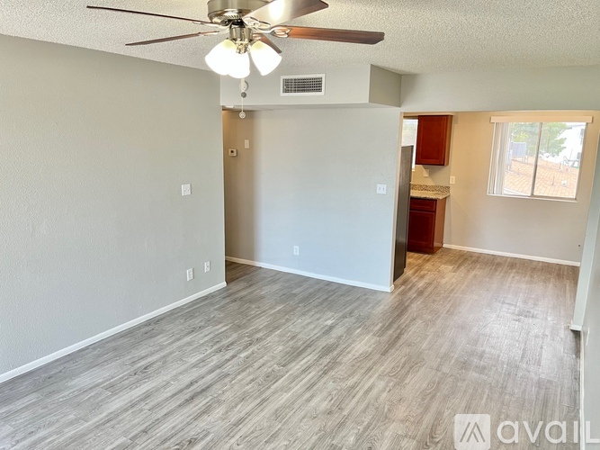 A room with a ceiling fan and light fixture, and a window with blinds.