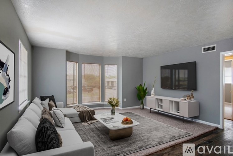 A modern living room with a grey sofa, a coffee table, and a flat-screen TV.