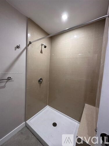 A bathroom with a walk-in shower and a white door.
