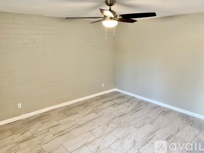 A room with a ceiling fan and a light hanging from it.
