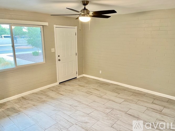 A room with a ceiling fan and a door leading to a balcony.
