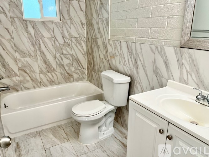 A white toilet sits next to a white sink in a bathroom.