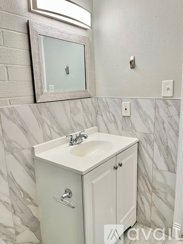 A white bathroom vanity with a mirror above it.