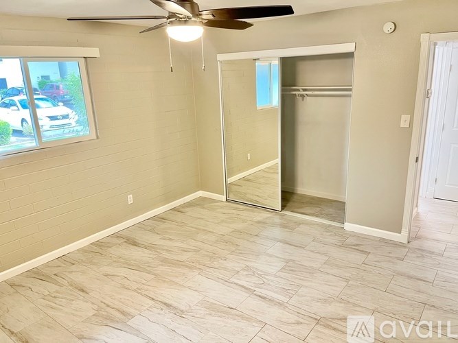 A room with a ceiling fan and a sliding glass door.