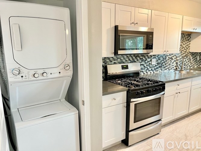 A white oven and dishwasher are in a kitchen with a black stove top.
