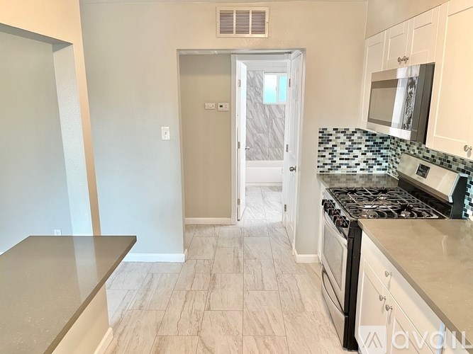 A kitchen with a stove top oven and a microwave above it.
