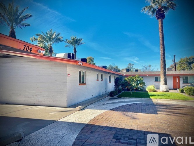 A house numbered 704 with a palm tree in front.
