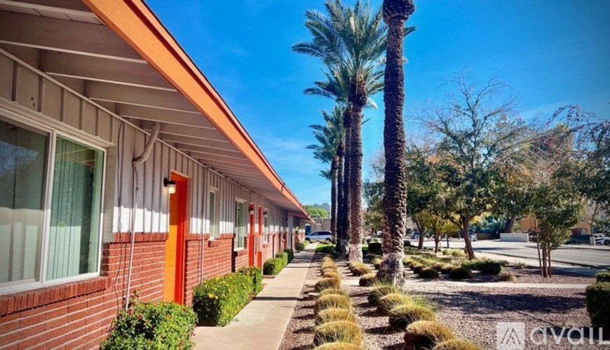 A row of houses with orange trim and a clear blue sky.