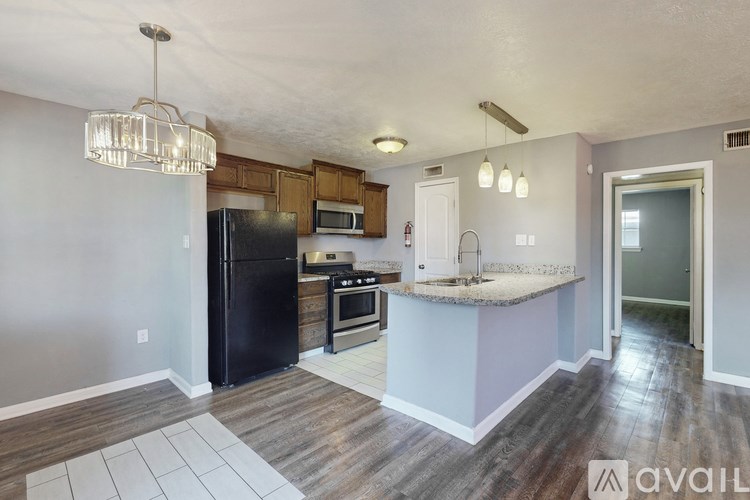 A kitchen with a black fridge and a white counter top.