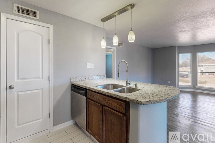 A kitchen with a white door, a granite countertop, and a sink.