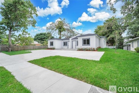 A house with a white exterior and a green lawn in front.
