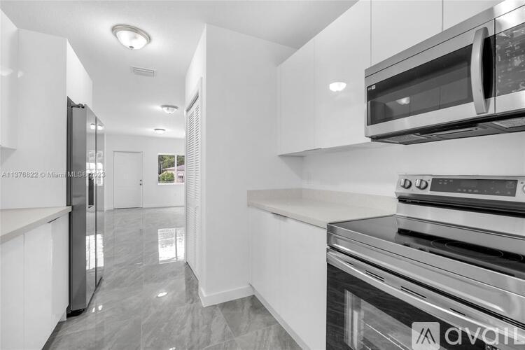 A modern kitchen with stainless steel appliances and white cabinets.