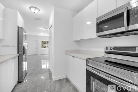 A modern kitchen with stainless steel appliances and white cabinets.
