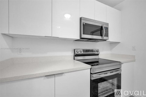 A modern kitchen with a microwave on top of the oven.