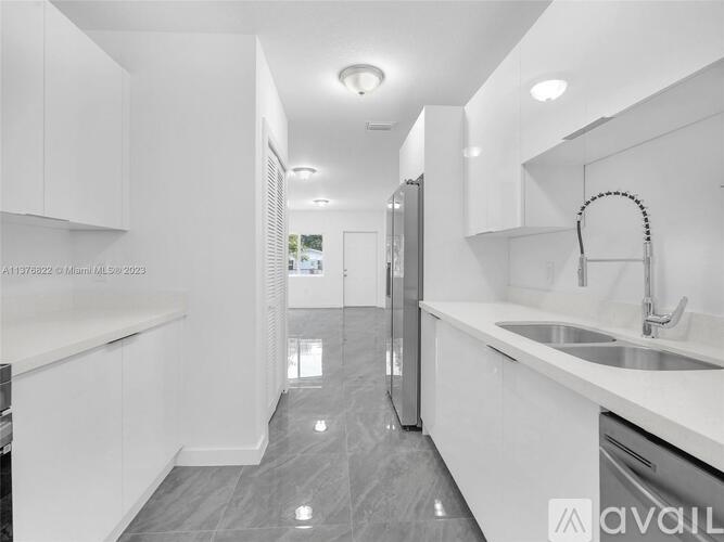 A modern kitchen with white cabinets and a grey floor.