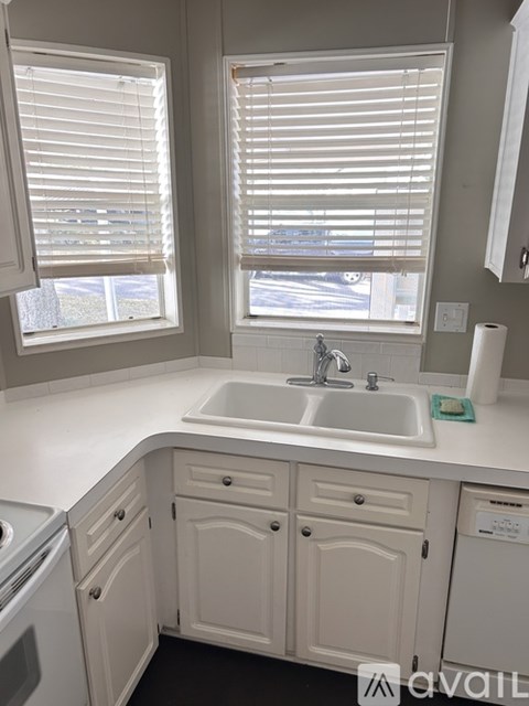 A white kitchen with a sink and a window.
