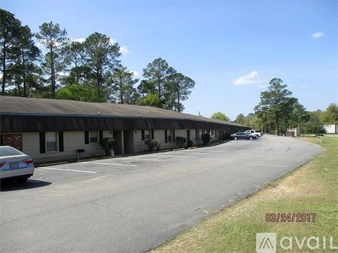 A parking lot with a building in the background and a car parked in the lot.